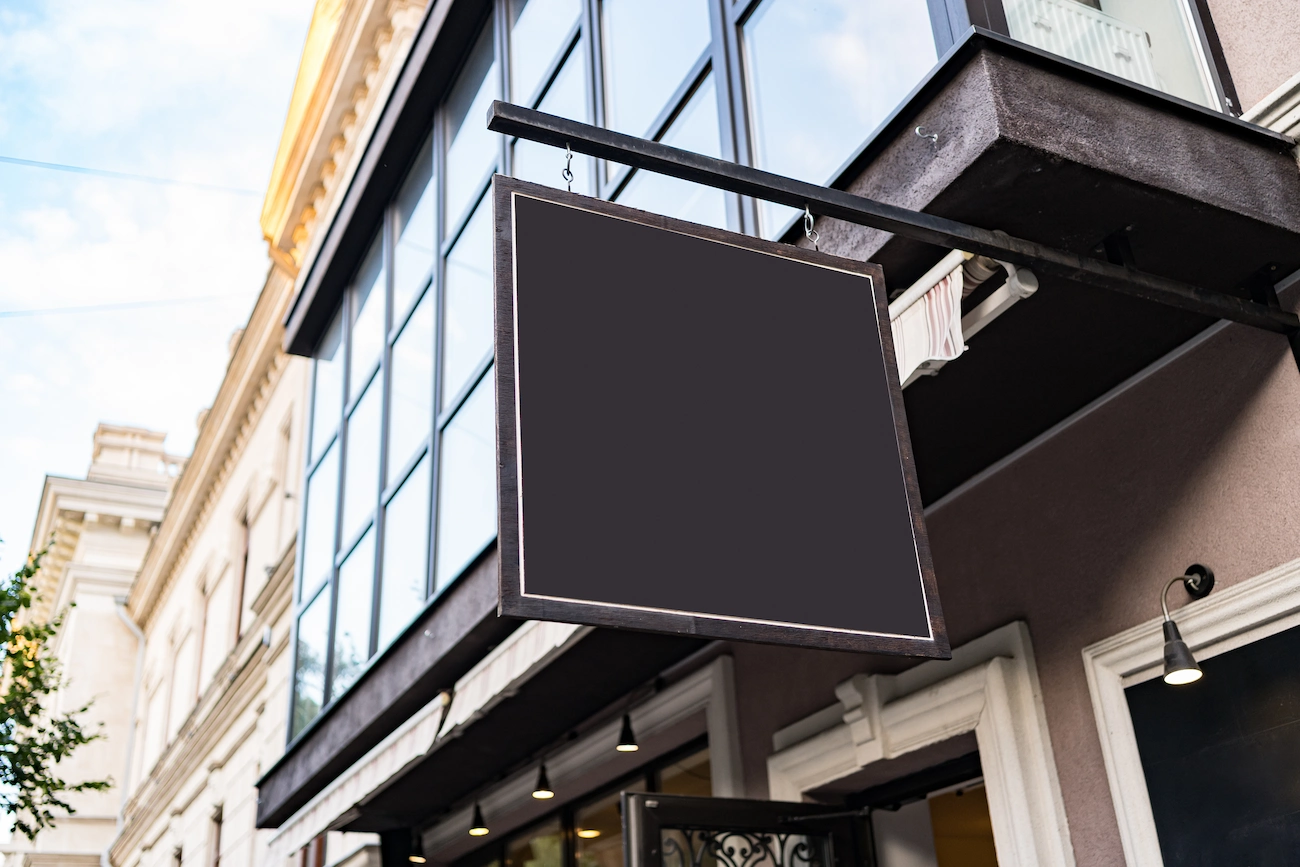 Cartel colgante en la fachada de un comercio, ejemplo de cartelería para exterior